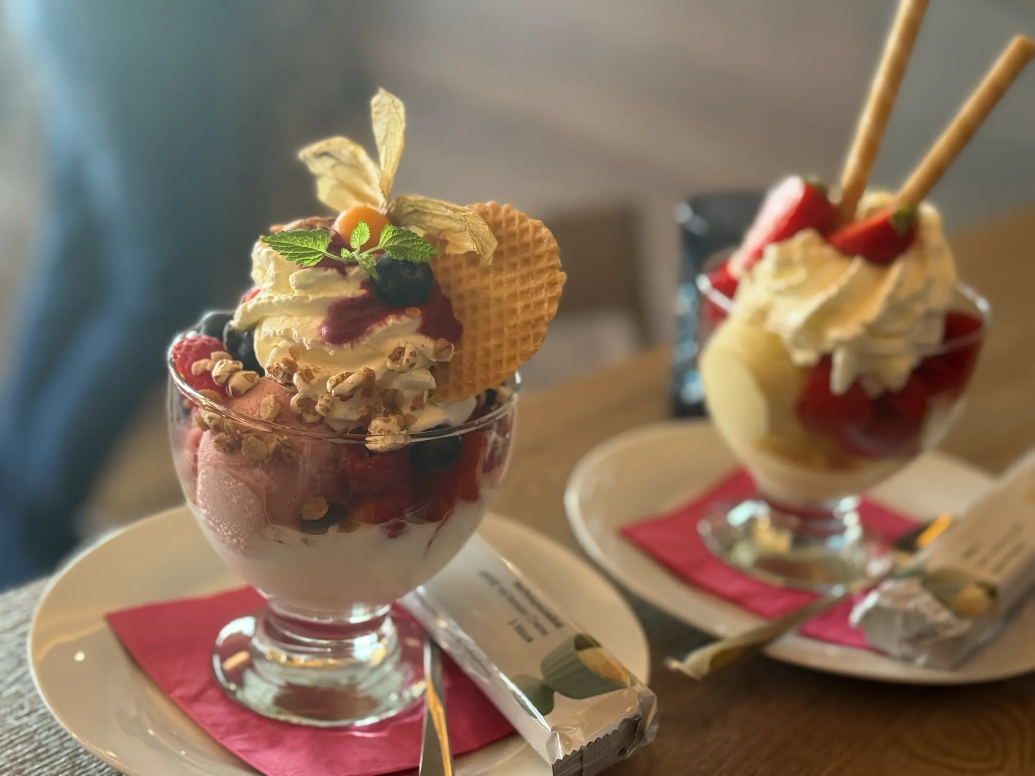 Fruchtige Eisdesserts im Glas mit Sahnetupfen und Beeren