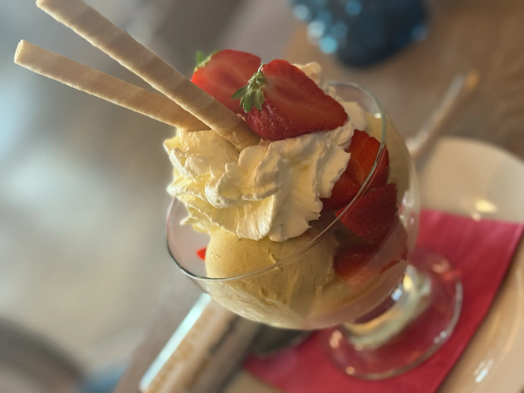 Hausgemachtes Erdbeereis im Glas – liebevoll dekoriert mit frischen Erdbeeren und Sahne