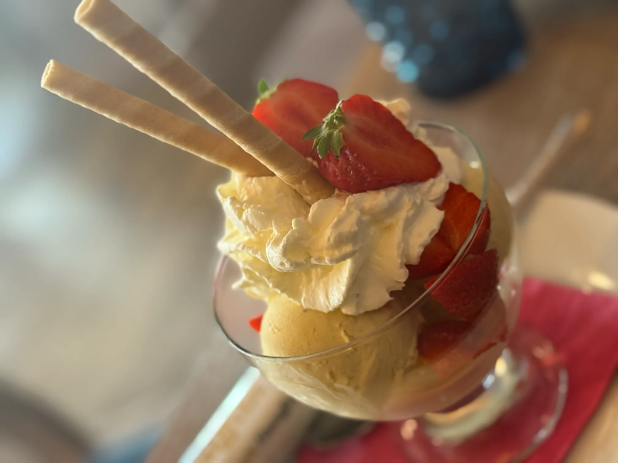 Hausgemachtes Erdbeereis im Glas – liebevoll dekoriert mit frischen Erdbeeren und Sahne